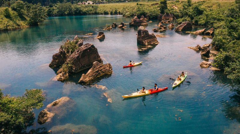 Activit&eacute; de kayak &agrave; Quang Binh, Vietnam, sur une rivi&egrave;re tranquille entour&eacute;e de paysages verdoyants